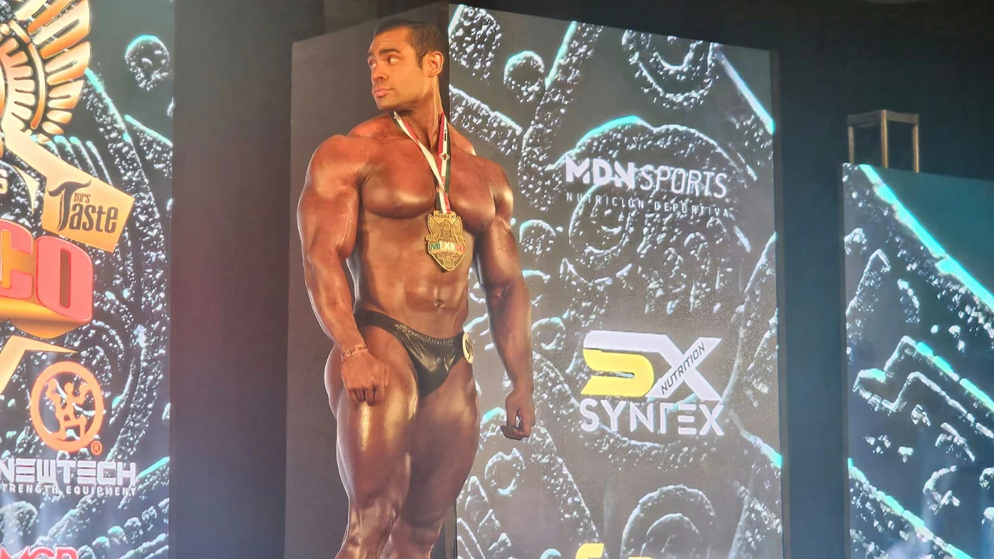 Athlete with his medal in front of the Syntex Nutrition backdrop
